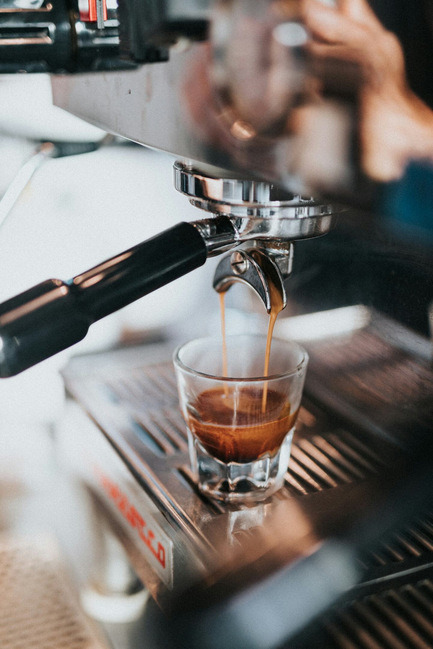 Espresso pull, steam rising from a small white cup.