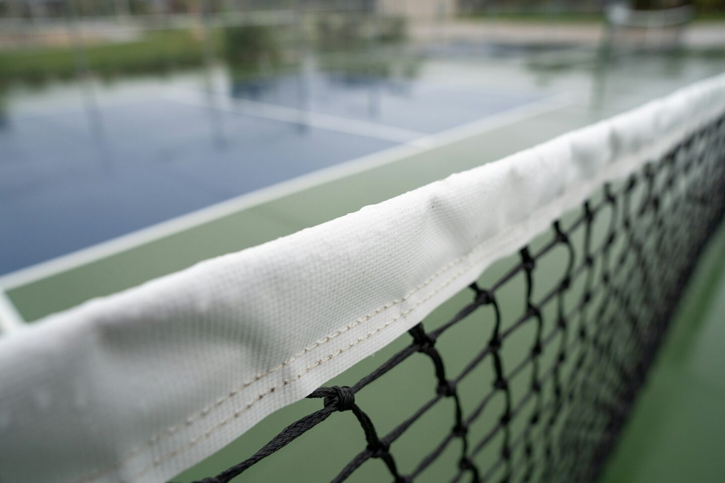 Indoor pickleball court mid-rally under warm light.